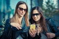 Two beautiful young women using smart phone Royalty Free Stock Photo