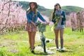 Two beautiful young women with a vintage bike in the field. Royalty Free Stock Photo