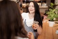 Two beautiful youthful smiling girls with dark hair,dressed in casual outfit,stand opposite each other and chat in a