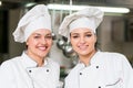 A two beautifull young female chef posing for camera