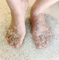 Pale beautifully manicured feet covered in clear gemstones