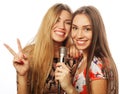 Two beauty girls with a microphone singing and having fun Royalty Free Stock Photo