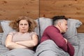 Two in bed, a woman complains, a man turned away in the other direction. Relationship concept