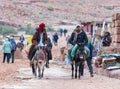 Two Bedouins ride donkeys and talk to each other in Petra near Wadi Musa city in Jordan