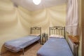 Two beds in a small simple bedroom in a hostel, motel or guest house. Concept of budget accommodation for rent or travel