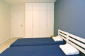 Two beds and a wardrobe in a modern bedroom Royalty Free Stock Photo