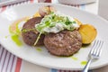 Two beef steaks with potatoes, fried egg and baked onions on a white plate Royalty Free Stock Photo