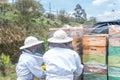Two beekeepers arrange honeycombs in a vehicle Royalty Free Stock Photo
