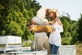 Two beekeepers works with honeycomb full of bees outdoors at sunny day. Man and woman Royalty Free Stock Photo