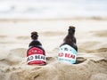 Two beer bottles buried in the sand