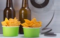 two beer bottles, next to the nachos buckets, on a light background with objects on the video