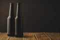 two beer bottles on a wooden table against a dark background/two beer bottles on a wooden table against a dark background, Royalty Free Stock Photo