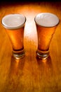 Two beer glasses on wet wood background Royalty Free Stock Photo