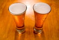 Two beer glasses on wet wooden background Royalty Free Stock Photo