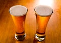 Two beer glasses on wood background Royalty Free Stock Photo