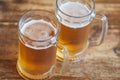 Two beer mugs closeup on wooden natural table.Two glass beer on wood background Royalty Free Stock Photo