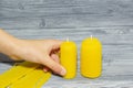 Two beeswax candles on a wooden background.