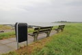 Two benches at the seawall at lLittle harbour de `griete` in the westerschelde sea at the dutch coast Royalty Free Stock Photo