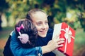 Two best friends hugging, emotional meeting with gift box in the park Royalty Free Stock Photo