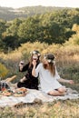 Two best friends on picnic in the field laying on the laid smiling