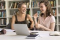 Two student girls laughing, engaged in conversation, funny jokes telling