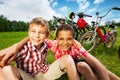 Two best friends sit on grass and hug with arms Royalty Free Stock Photo