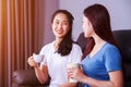 Two best friends talking and drinking a cup of coffee on sofa at Royalty Free Stock Photo