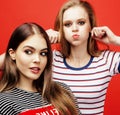 Two best friends teenage girls together having fun, posing emotional on red background, besties happy smiling, lifestyle Royalty Free Stock Photo