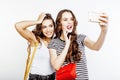 Two best friends teenage girls together having fun, posing emotional on white background, besties happy smiling, making