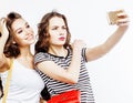 Two best friends teenage girls together having fun, posing emotional on white background, besties happy smiling, making Royalty Free Stock Photo