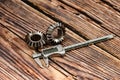 Two bevel gears and vernier caliper on a wooden background