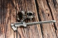 Two bevel gears and vernier caliper on a wooden background