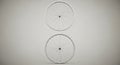 Two bicycle wheels are arranged vertically against a neutral background. Each wheel Royalty Free Stock Photo