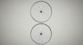 Two bicycle wheels are arranged vertically against a neutral grey background. Each Royalty Free Stock Photo