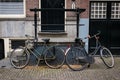 Two bicycles in Amsterdam lean against a stoop