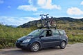 Two bicycles mounted on roof of car against sky Royalty Free Stock Photo