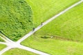 Two bicyclists approach a juncture in a green field