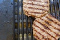 Two big bio meat burger patios grilling on an electric bbq grill. Concept of unhealthy greasy manly food Royalty Free Stock Photo