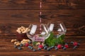 Two big glasses with fruit juice. Bilberries, raspberries, peanuts in a bowl, mint and on a dark brown wooden background Royalty Free Stock Photo