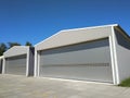 Two big industrial metal hangar or warehouse with closed doors. Metal garage building for manufacturing usage. Royalty Free Stock Photo