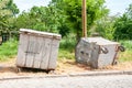 Two big old metal dumpster garbage cans on the street damaged by vandals