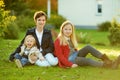 Two big sisters and their little brother having fun outdoors. Two young girls holding toddler boy on autumn day. Children with Royalty Free Stock Photo