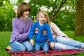 Two big sisters and their toddler brother having fun in city park on warm spring day. Children having a picnic outdoors. Three Royalty Free Stock Photo