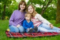 Two big sisters and their toddler brother having fun in city park on warm spring day. Children having a picnic outdoors. Three Royalty Free Stock Photo