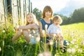 Two big sisters and their toddler brother having fun outdoors. Two young girls holding baby boy on summer day. Children with large Royalty Free Stock Photo