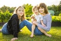 Two big sisters and their toddler brother having fun outdoors. Two young girls holding baby boy on summer day. Children with large Royalty Free Stock Photo