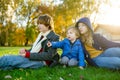 Two big sisters and their toddler brother having fun outdoors. Two young girls with a toddler boy on autumn day. Children with Royalty Free Stock Photo