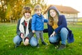 Two big sisters and their toddler brother having fun outdoors. Two young girls with a toddler boy on autumn day. Children with Royalty Free Stock Photo