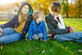 Two big sisters and their toddler brother having fun outdoors. Two young girls with a toddler boy on autumn day. Children with Royalty Free Stock Photo