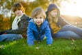 Two big sisters and their toddler brother having fun outdoors. Two young girls with a toddler boy on autumn day. Children with Royalty Free Stock Photo